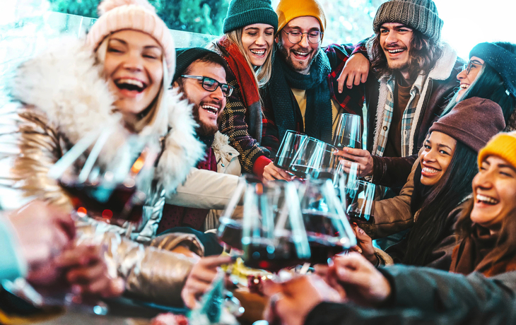 Freunde, die im Restaurant mit Rotwein anstoßen